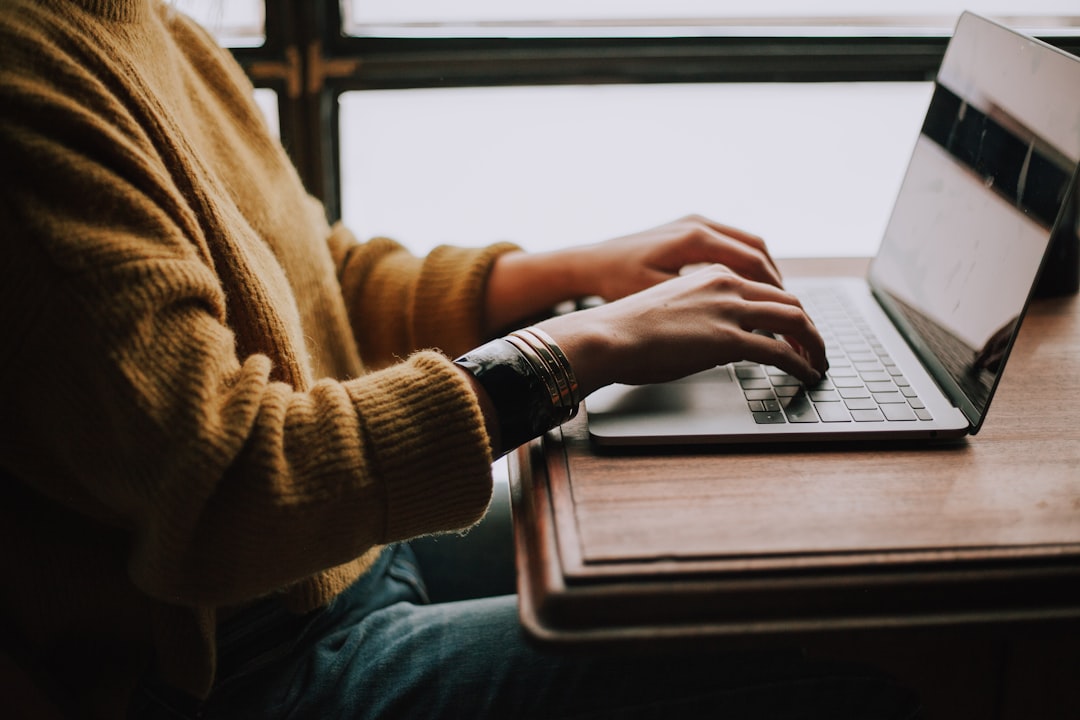 Photo by Christin Hume person sitting front of laptop