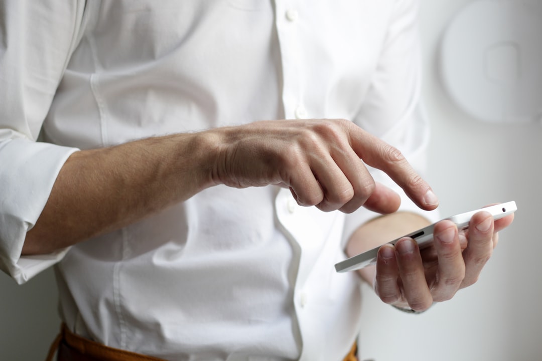 Photo by NordWood Themes person holding white Android smartphone in white shirt
