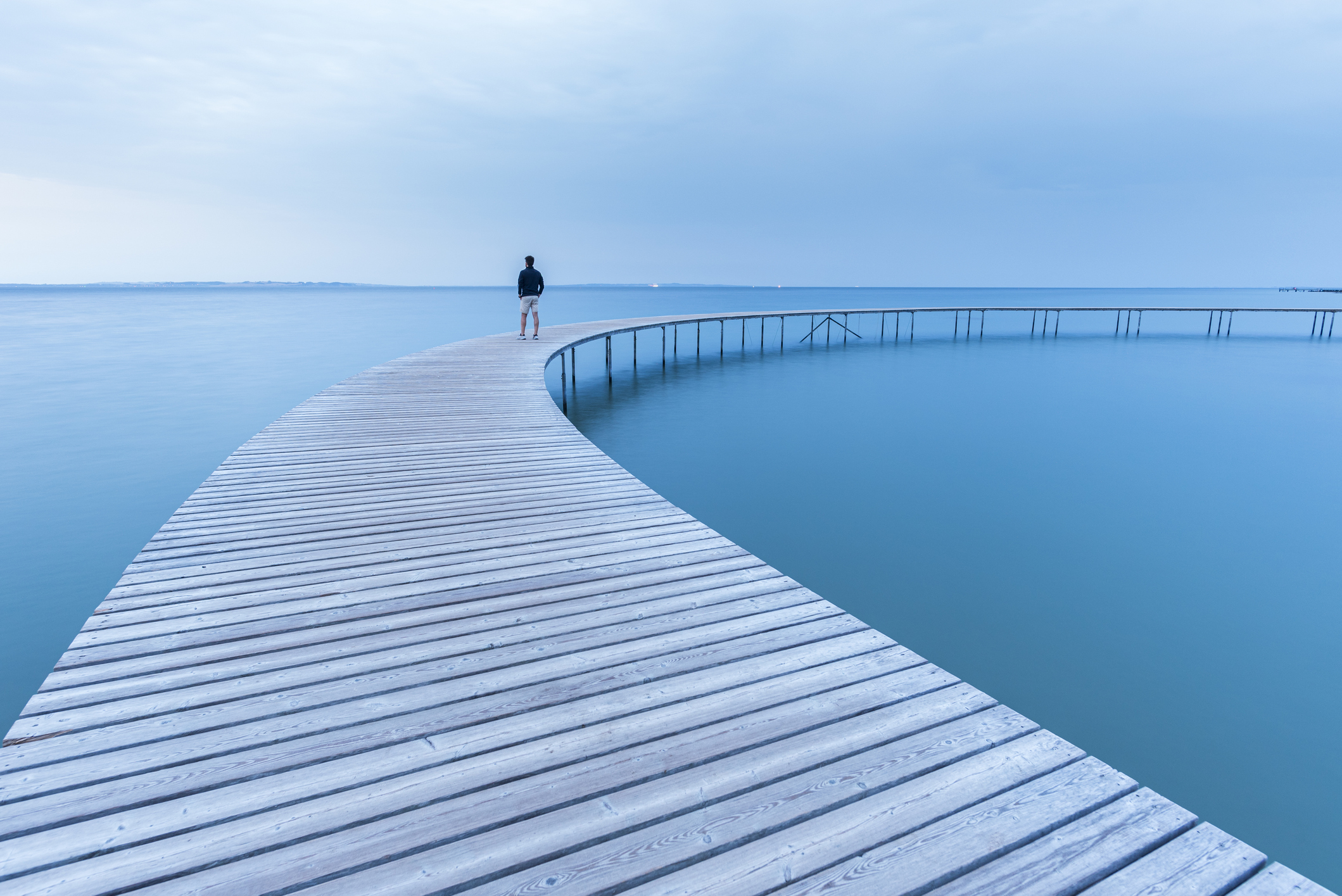 Man on wooden walkway at dusk, Denmark